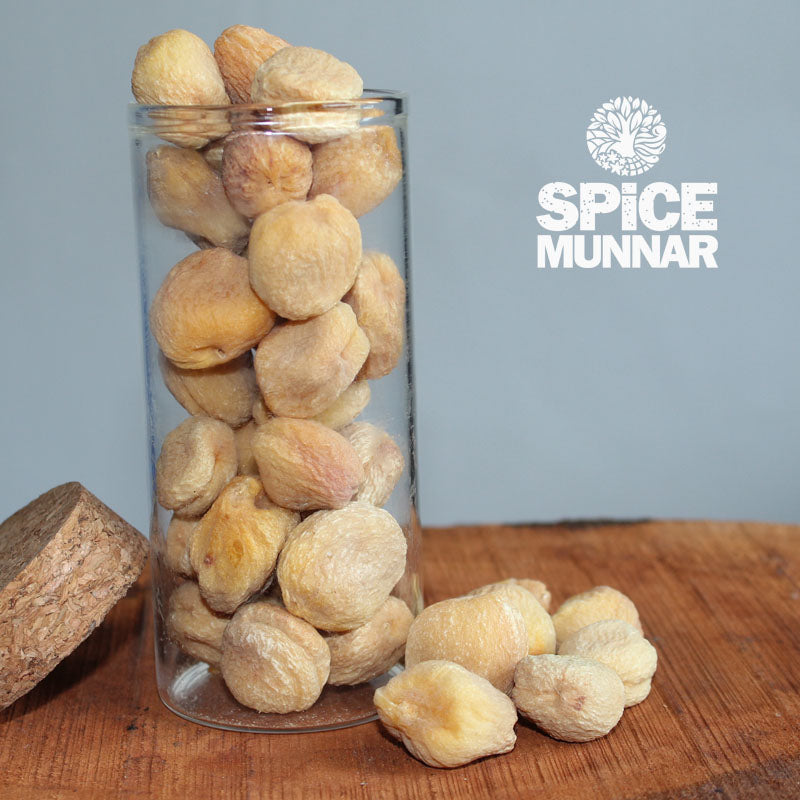 Glass jar filled with apricots on a wooden surface, with 'Spice Munnar' logo in the corner.