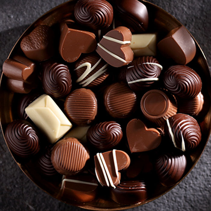Assorted chocolate candies in a round metal tray  