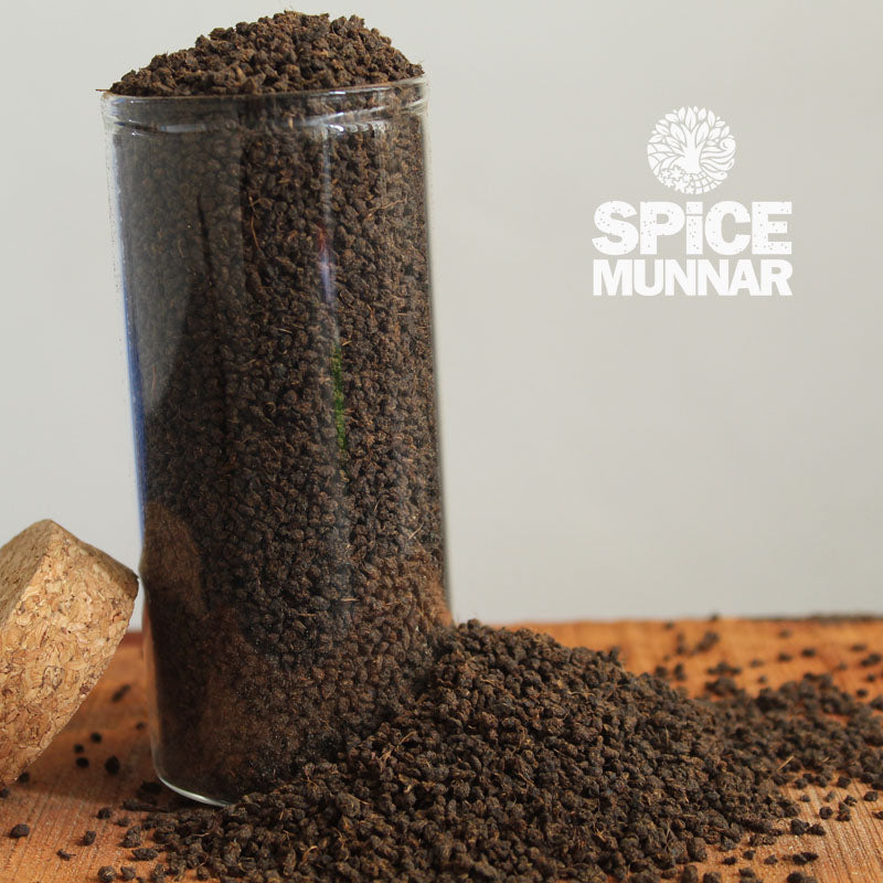 Glass container filled with Tea Powder with 'Spice Munnar' branding.